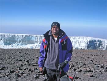 Kwameh at Uhuru Peak with the Southern Icefields in the background.